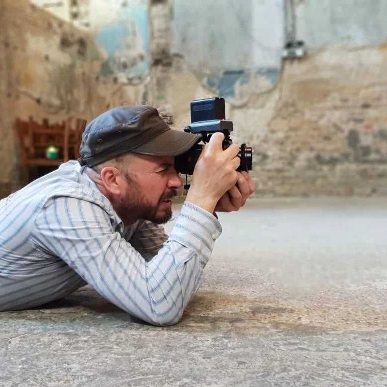 Mat Green, founder, lying on the floor to film with a camera